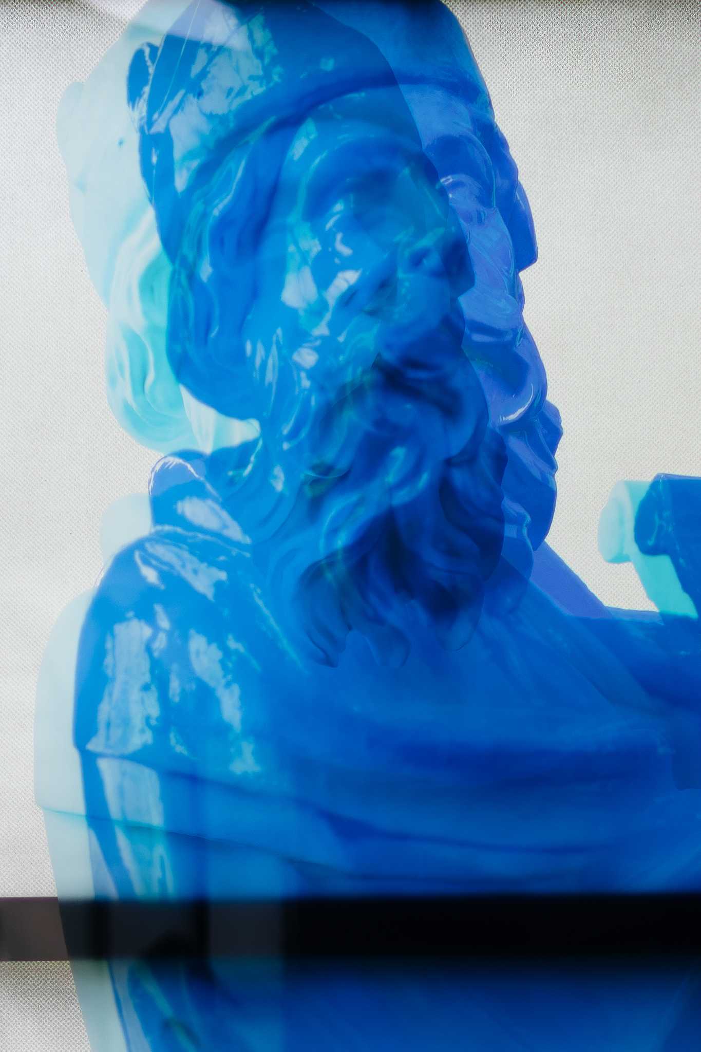 Derselbe Druck aus der Nähe: der blaue Prophet auf dem Fensterglas, seine Konturen doppeln sich, wo sich die Ebenen überlagern, darunter quert eine dunkle Sprosse.