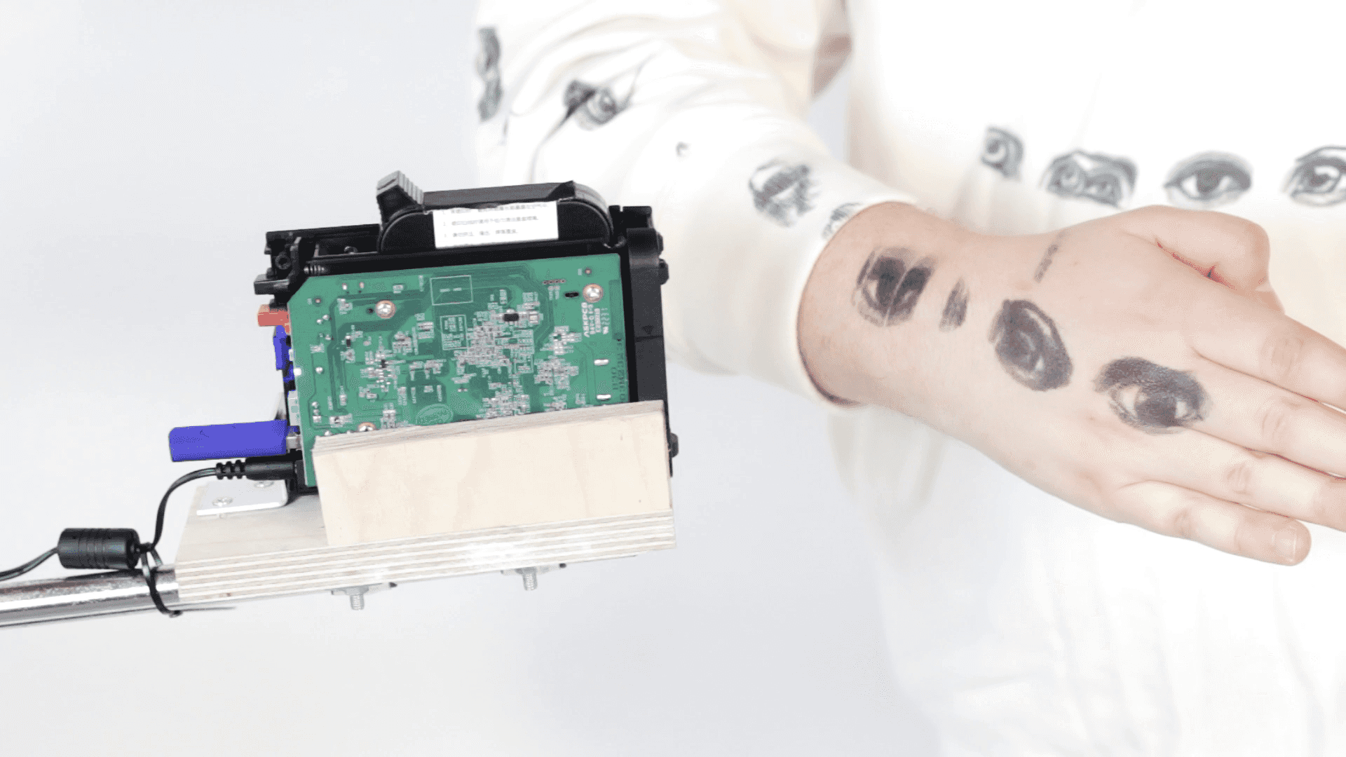 Ein Handdrucker, der Augen auf den Arm einer Person druckt